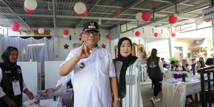 Pj Wali Kota Bersama Ketua TP-PKK Kotamobagu Beri Hal Suara di TPS 7 Kotobangon